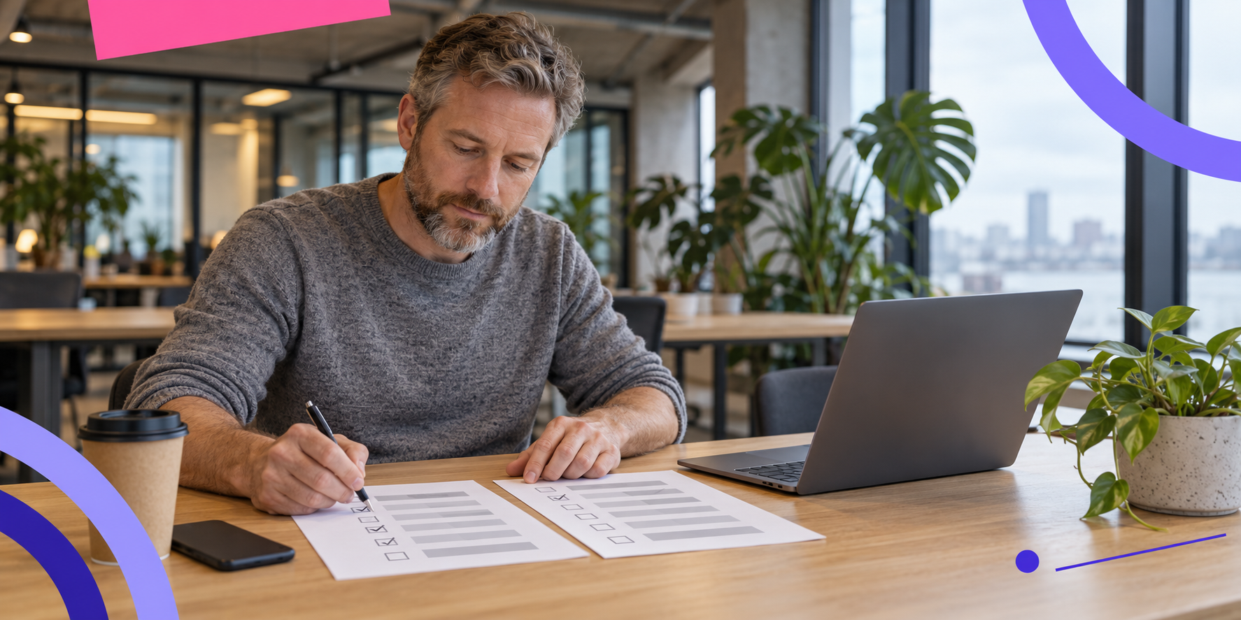 Homme cochant des cases sur deux check-lists imprimées à une table de coworking en comparant des plateformes, ordinateur à côté